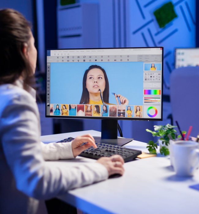 Creative creator doing portrait retouch using color grade late at night in professional editing office. Graphic editor retouching photos of a client on performance pc before deadline